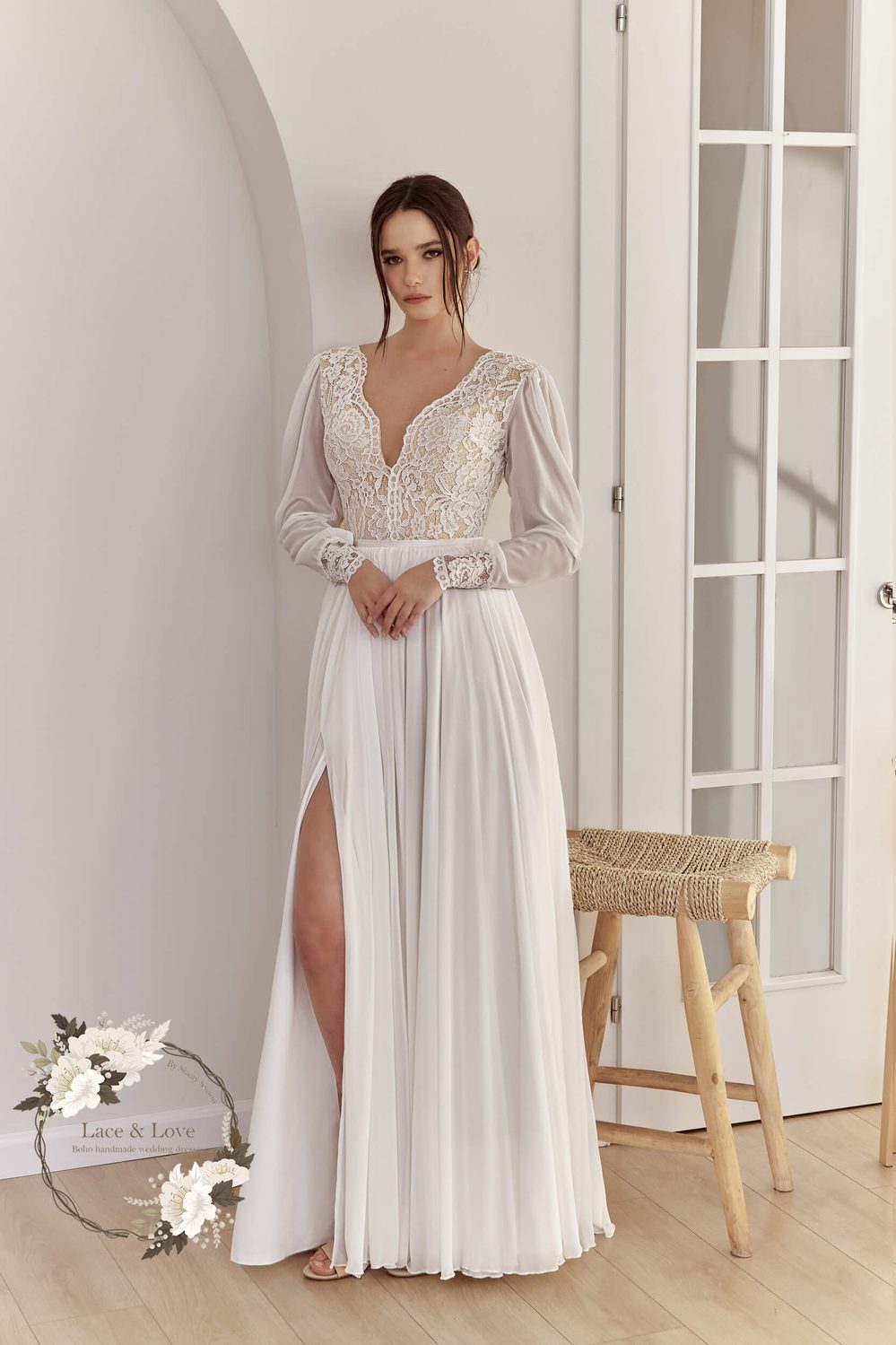 Bride in a boho lace and chiffon wedding dress with an open back and a high slit, photographed outdoors.