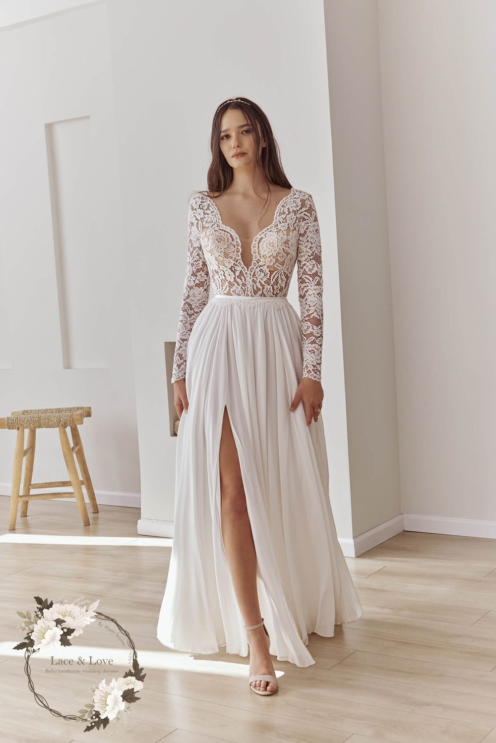 Wedding dress with long fitted sleeves in vintage French lace, the pattern visible on the arms.