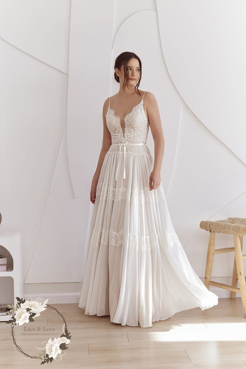 Bride in an A-line wedding dress with a fitted lace bodice and a tiered chiffon skirt that flares from the waist.
